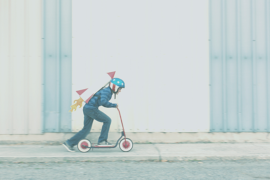Optimized for Speed image of kid on scooter with rocket on back