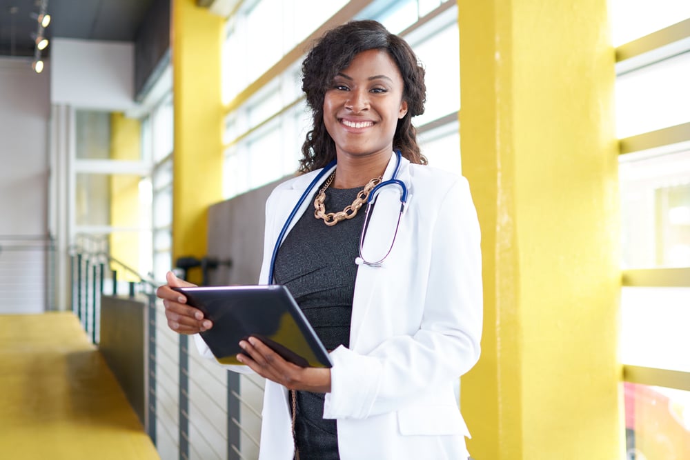 Lynn Medical image of a female doctor holding her patient chart on digital tablet in bright modern hospital