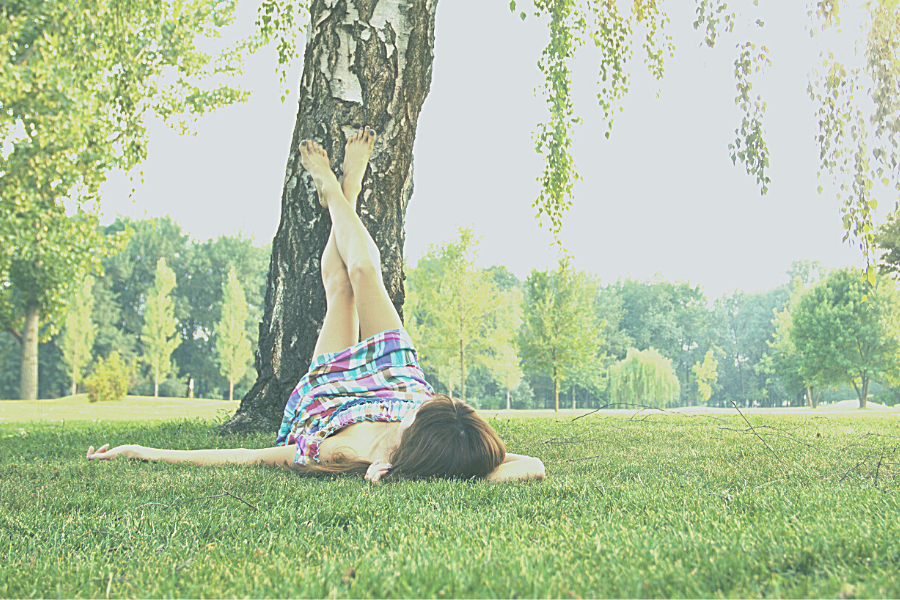 Save time image of women laying on ground with feet on tree